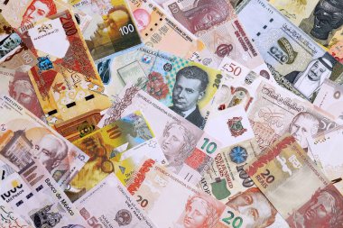 Çeşitli para birimleri para banknotları sarı ve turuncu renklerde. Farklı ülkelerden gelen birçok nakit para yığını yakın mesafede. Dünya ekonomisi ve döviz kuru kavramı