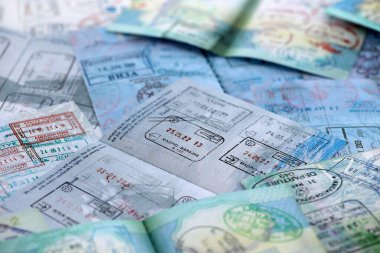 Seyahat ve sınır geçişinden sonra renkli pullarla dolu büyük bir pasaport sayfası. Turizm ve sınır denetimi kavramı. Göçmenlik ve dünya çapında seyahat
