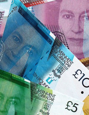 Cebelitarık banknotları masanın üzerine yığılmış. Gibraltar GIP para birimi faturaları büyük miktarda. Cebelitarık 'ta ekonomi, vergilendirme ve bankacılık kavramı