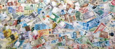 Dünyanın çeşitli para birimlerinden farklı renkte banknotlar. Para değişimi konsepti. Masada yığınla para var. Yakın plan.