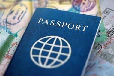 Seyahat ve sınır geçişinden sonra içi renkli pullarla dolu bir pasaport. Turizm ve sınır denetimi kavramı. Göçmenlik ve dünya çapında seyahat