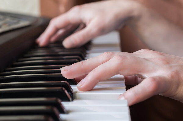 Woman hands playing piano music.