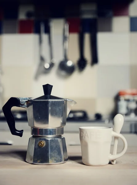 red coffee cup and  vintage coffeepot on kitchen stove