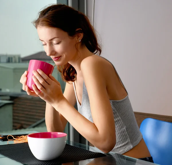 美丽的年轻女子，与粉色的茶杯 — 图库照片