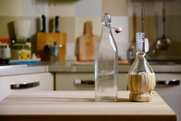 Botellas sobre mesa de madera sobre fondo de cocina —  Fotos de Stock