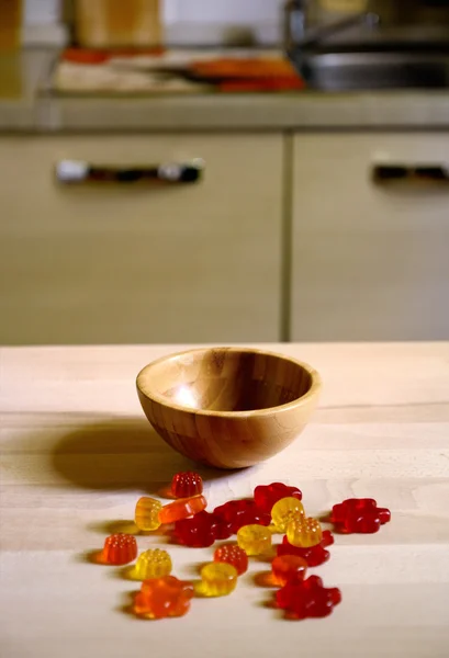 Ahşap masa mutfak arka plan üzerinde renkli sakızlı şeker ayı — Stok fotoğraf