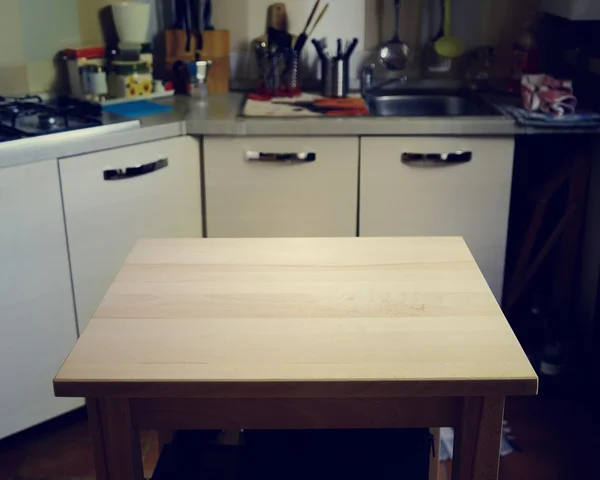 Mesa de madera sobre fondo borroso de la cocina — Foto de Stock