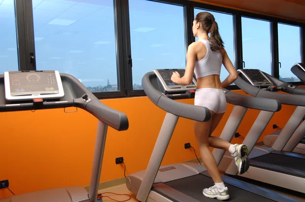 Entrenamiento de la mujer en el gimnasio en tapis roulant — Foto de Stock