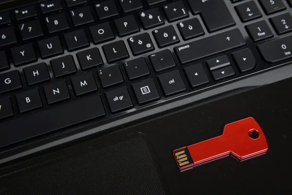 Red usb key on black keyboard — Stock Photo, Image