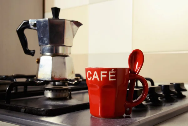 Rode koffie beker en vintage koffiepot op keuken kachel — Stockfoto