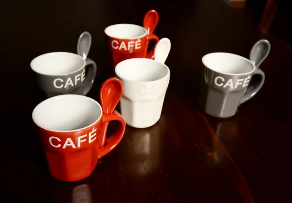 Colored Coffee cups on wooden table — Stock Photo, Image