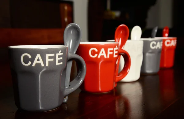 Colored Coffee cups on wooden table — Stock Photo, Image