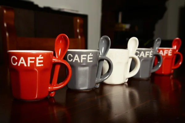 Colored Coffee cups on wooden table — Stock Photo, Image