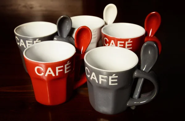 Gekleurde koffie cups op houten tafel — Stockfoto