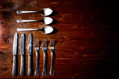 koyu ahşap masa üzerinde eski kullanılan çatal bıçak takımı