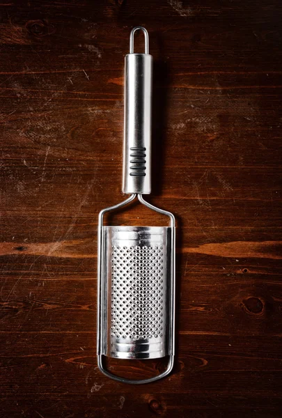 Cheese grater  on dark wooden table — Stock Photo, Image