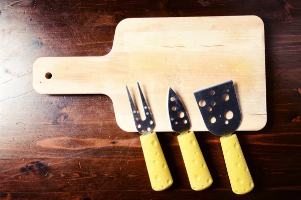 Küçük peynir bıçak ve koyu ahşap masa üzerinde kesme tahtası — Stok fotoğraf