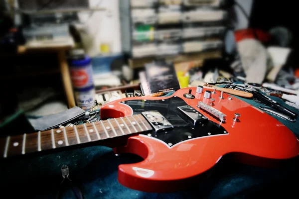 Red guitar in maintenance — Stock Photo, Image