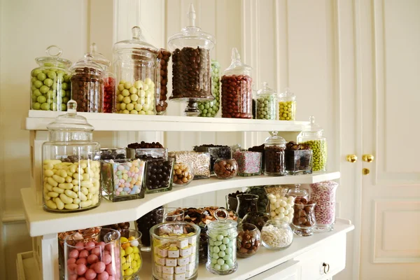 Cuencos de caramelo de color en la creencia blanca — Foto de Stock