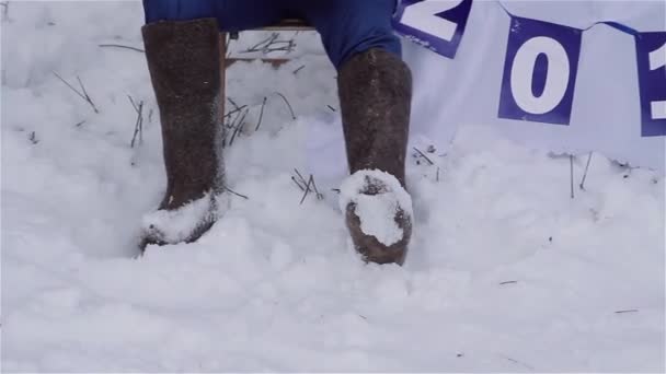 Homme et femme assis dans des bottes abus en hiver . — Video