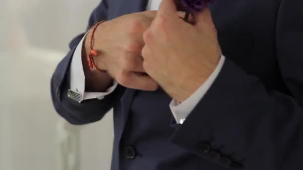 Der Bräutigam sichert den Boutonniere an der Jacke. — Stockvideo