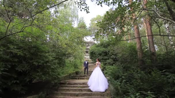 Nevěsta a ženich jsou stojící na schodech. — Stock video