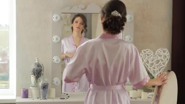 The girl stands in the mirror looking at herself in the mirror — Stock Video