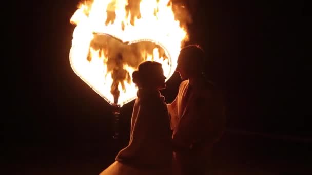 The couple dancing on the background of the fiery heart. — Stock Video