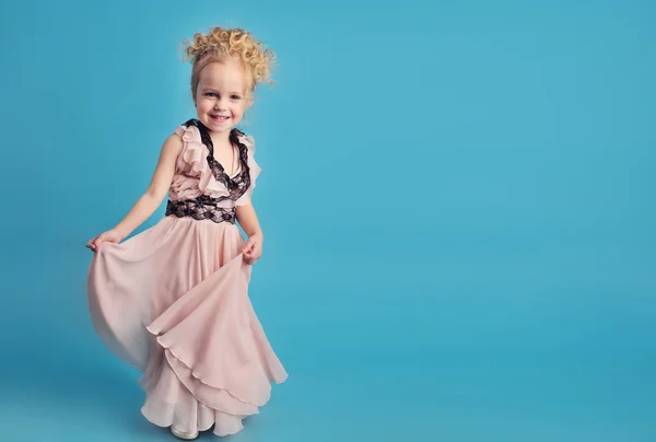 Niña en un vestido largo y un abrigo de piel — Foto de Stock