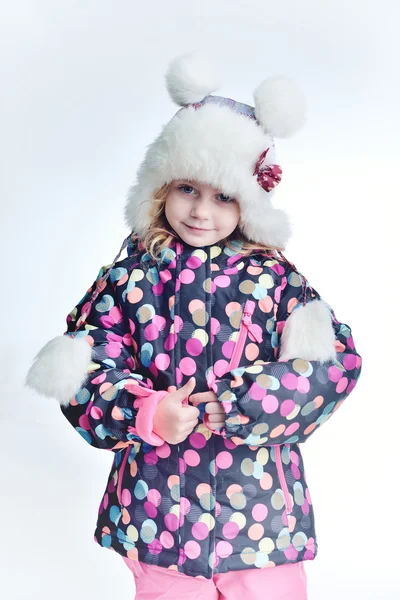 Ładny zabawny dziecko w kolorowy zimowe ubrania zabawy ze śniegiem, na zewnątrz podczas opadów śniegu. Na zewnątrz aktywny wypoczynek z dziećmi w zimie. Dziecko kapelusz, ręcznie rękawice z paskami. — Zdjęcie stockowe