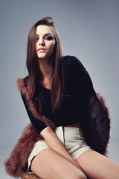 Portrait of attractive stylish woman in fur against grey background. — Stock Photo, Image