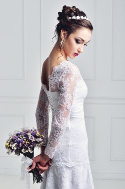 Beyaz arka planda moda düğün saç stili olan güzel bir gelin. Yakından güzel bir gelinin portresi. Düğün için. Stüdyo fotoğrafı. Yüzünde peçeyle güzel bir gelin portresi.