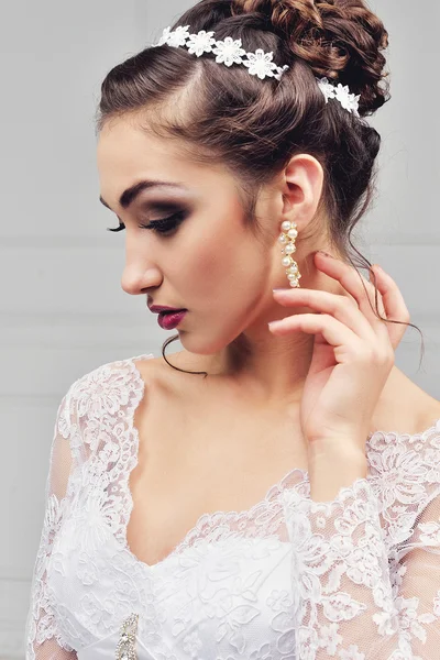 Όμορφη νύφη με fashion wedding hairstyle - σε λευκό φόντο.Κοντινό πορτρέτο της νεαρής πανέμορφης νύφης. Γάμος. Studio shot.Beautiful πορτρέτο νύφη με πέπλο πάνω από το πρόσωπό της — Φωτογραφία Αρχείου