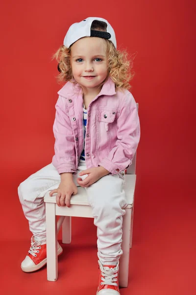 Portréja egy aranyos kis lány a divatos ruhák. gyönyörű gyermek — Stock Fotó