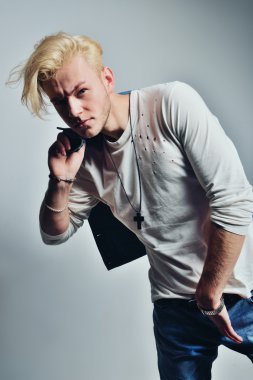 Yakışıklı genç moda erkek model ile ceket omzunun üzerinden poz. Beyaz arka plan üzerinde izole tam vücut uzunluğu portre.