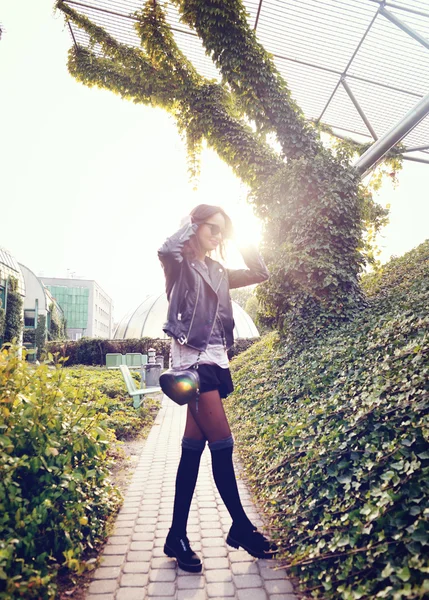 Modell i solglasögon och svart läder jacka poserar utomhus — Stockfoto