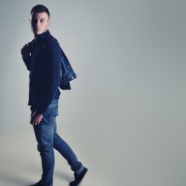 yakışıklı olan şık kot giysilerle poz