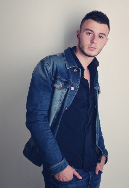 yakışıklı olan şık kot giysilerle poz