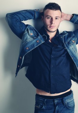 yakışıklı olan şık kot giysilerle poz