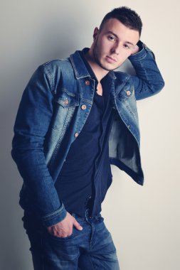 yakışıklı olan şık kot giysilerle poz