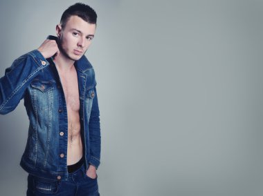 yakışıklı olan şık kot giysilerle poz