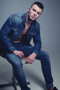 yakışıklı olan şık kot giysilerle poz