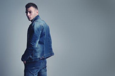 yakışıklı olan şık kot giysilerle poz