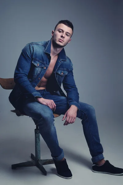 Handsome guy posing in stylish jeans clothes — Stock Photo, Image