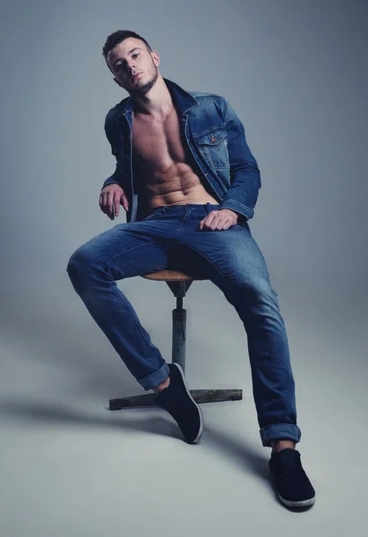 Schöner Kerl posiert in stylischen Jeans-Klamotten — Stockfoto