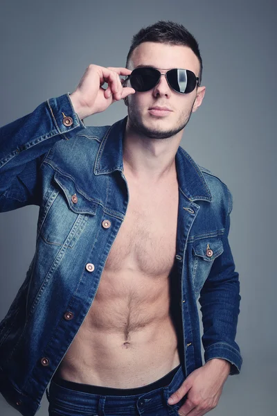 Handsome guy posing in stylish jeans clothes — Stock Photo, Image