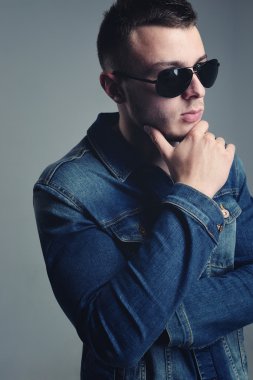 yakışıklı olan şık kot giysilerle poz