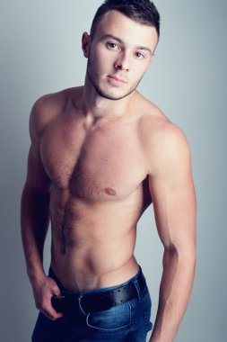 Genç yakışıklı adam bir güzel gövdeli bir stüdyoda poz