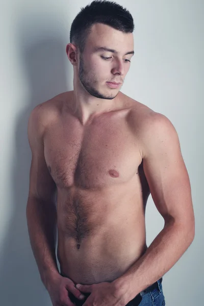 Junger hübscher Kerl posiert in einem Studio mit einem schönen Körper — Stockfoto