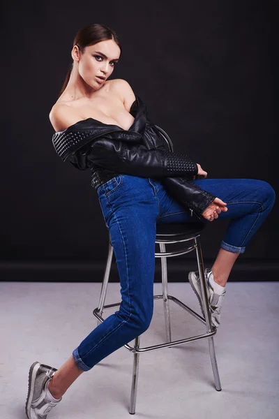 Довольно молодая сексуальная чувственная женщина моды позирует на белом фоне стены, одетый в джинсы в стиле хипстера — стоковое фото